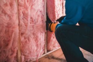 Vakman brengt isolatiewol aan in een wand