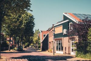 Nederlandse woonstraat met bomen en woonhuizen met zonnepanelen